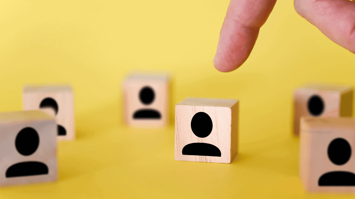 The search for new managers to lead organizations and teams is shown using wooden cubes, on a yellow background.