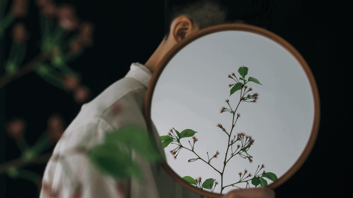 Man with Flowers Reflecting in Mirror