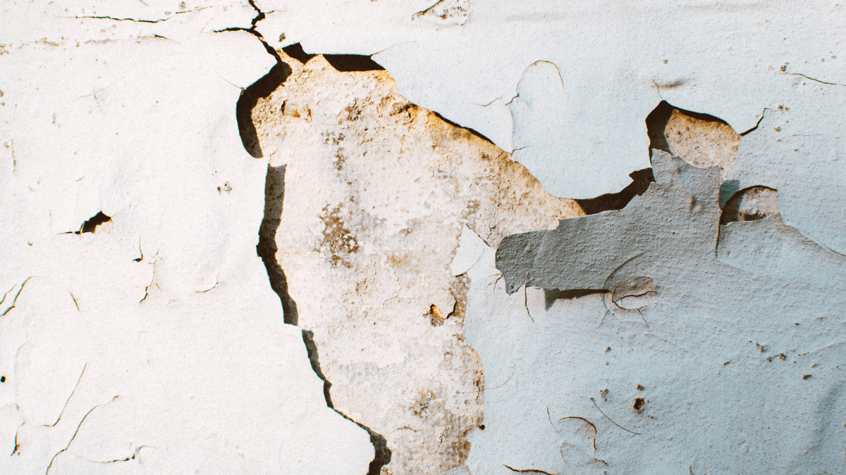 wallpaper peels off a cracked wall