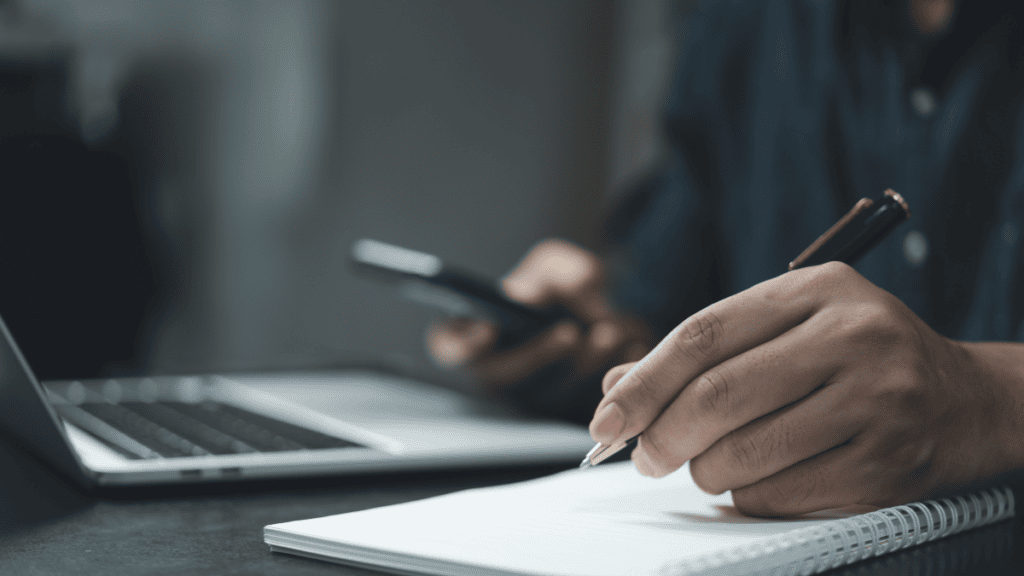 a pen hovers over a pad with technology in the background
