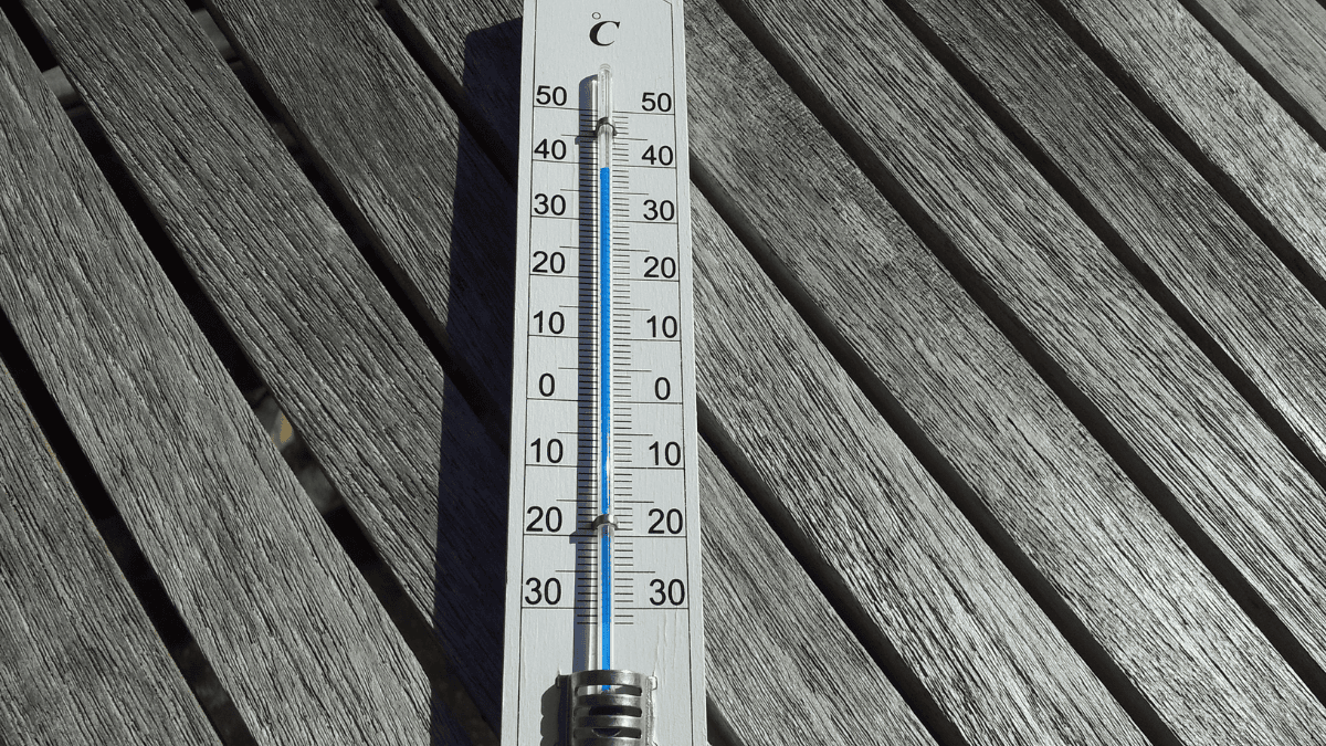 a mercury thermometer on a wood panelled wall